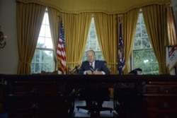 President Gerald R. Ford signs a proclamation granting a pardon to former President Richard Nixon in the Oval Office, September 8, 1974. (Courtesy Gerald R. Ford Presidential Library)