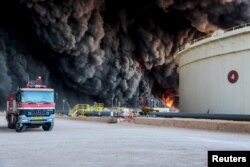 FILE - Fire rises from an oil tank in the port of Es Sider, in Ras Lanuf, Libya, Jan. 6, 2016. A Petroleum Facilities Guards blamed the blazes on attacks by Islamic State militants.