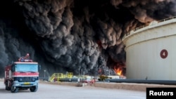 FILE - Fire rises from an oil tank in the port of Es Sider, in Ras Lanouf, Libya, Jan. 6, 2016. A Petroleum Facilities Guards blamed the blazes on attacks by Islamic State militants.