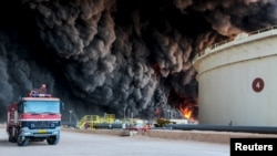 FILE - Fire rises from an oil tank in the port of Es Sider, in Ras Lanuf, Libya, Jan. 6, 2016. A Petroleum Facilities Guards blamed the blazes on attacks by Islamic State militants.