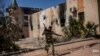 FILE - A fighter of the Libyan forces, affiliated with the Tripoli government, runs for cover while fighting against Islamic State positions in Sirte, Libya, Sept. 22, 2016. 