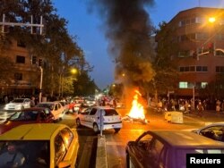 Sebuah sepeda motor polisi terbakar selama protes atas kematian Mahsa Amini, seorang perempuan yang meninggal setelah ditangkap oleh "polisi moral" republik Islam itu, di Teheran, Iran 19 September 2022. (Foto: WANA via Reuters)