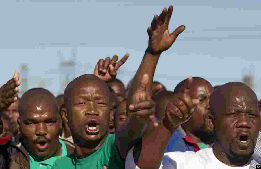 Mine workers sing before a memorial service near the Lonmin's platinum mine in Marikana, South Africa, August 16, 2013.