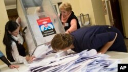 Election officials empty a ballot box during rebel elections at a polling station in the city of Donetsk, eastern Ukraine, Nov. 2, 2014. 