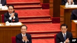 2012年3月11日，令计划(坐在温家宝后面)和胡锦涛、温家宝一起出席中国人大会议