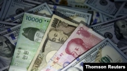 FILE - South Korean won, Chinese yuan and Japanese yen notes are seen with U.S. $100 notes in this illustration taken in Seoul, South Korea, Dec. 15, 2015.