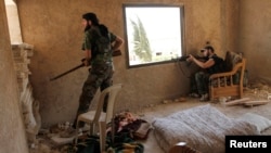  Free Syrian Army fighters take cover inside a house near the air force intelligence headquarters in Aleppo, Syria, August 1, 2013.