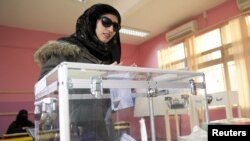 A woman casts her ballot at a polling station in Ardiyah, Kuwait, December 1, 2012.