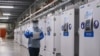 FILE - A worker passes a line of freezers holding coronavirus disease (COVID-19) vaccine candidate BNT162b2 at a Pfizer facility in Puurs, Belgium in an undated photograph. 