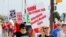 FILE - Striking General Motors Detroit-Hamtramck Assembly plant workers and their supporters walk the picket line during the United Auto Workers (UAW) national strike in Hamtramck, Michigan, Sept. 22, 2019.