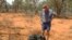 Australian farmer James Stirton stands next to a ball of twisted metal, purported to be fallen space junk, on his farm in southwestern Queensland in this undated handout photograph received March 28, 2008.