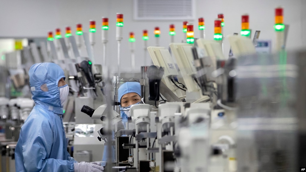 资料照片：穿着防护设备的员工在位于北京的中国瑞萨电子半导体生产工厂工作。(2020年5月14日）(photo:VOA)