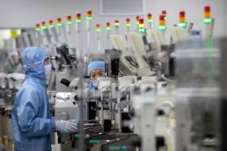 Seorang karyawan mengenakan APD saat bekerja di fasilitas produksi semikonduktor Renesas Electronics saat berlangsungnya tur khusus wartawan yang diselenggarakan pemerintah di Beijing, China, 14 Mei 2020. (Foto: dok)