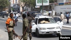 Somali government soldiers secure the scene of a car bomb attack in the capital Mogadishu, Feb. 10, 2014. 