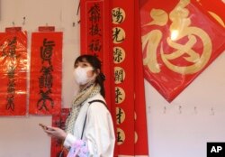 Seorang perempuan mengenakan masker di tengah pandemi COVID-19, berjalan melalui lorong-lorong di sepanjang pasar Jalan Dihua di Taipei, Taiwan, yang dihiasi dekorasi menyambut Tahun Baru Imlek, Rabu, 10 Februari 2021.