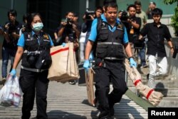 Thai forensic experts carry evidence as they leaves from a site of bomb blast at the Phramongkutklao Hospital, in Bangkok, Thailand, May 22, 2017.
