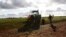FILE - A farmer walks next to his tractor at a farm near Parkes, 357 kilometers west of Sydney, Australia. Agriculture is a key focus of the delegation. 