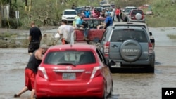 Residentes se mueven por una carretera inundada en Toa Baja, Puerto Rico.