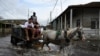 ARCHIVO - Personas viajan en un carro a través de aguas inundadas después del paso del huracán Rafael en Batabano, provincia de Artemisa, Cuba, el 7 de noviembre de 2024.
