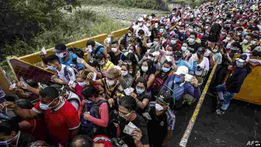 베네수엘라와 콜롬비아를 잇는 쿠쿠타의 시몬 볼리바르 다리에서 신종 코로나 바이러스를 피하기 위해 마스크를 착용한 베네수엘라인들이 국경을 넘어가고 있다.