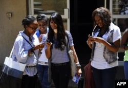 FILE - Students look at a new app on their mobile device, where they can receive and share information in real-time in the event of a health crisis, epidemic(s), and natural disasters.