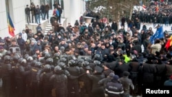 Protesters push a riot police line outside the parliament building in Chisinau, Moldova, Jan. 20, 2016. Hundreds of protesters broke through police lines on Wednesday to get into Moldova's parliament after it voted in a new prime minister.