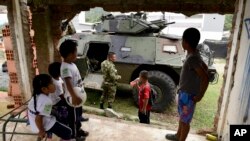 Children look at an armored vehicle in Toribio, southwest Colombia, Oct. 30, 2019. 
