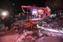 Personas se reúnen en el lugar de un ataque aéreo en el mercado de Maaret al-Numan, en Idlib, Siria, el 21 de mayo de 2019. Al menos 12 personas murieron y otras 18 resultaron heridas según la ONG británica Observatorio Sirio para los DDHH.