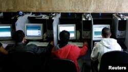 အင်တာနက်ကဖေးလ်ဆိုင်တွင် ကွန်ပျူတာသုံးစွဲနေသူများ။