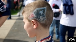 At the Super Bowl in Houston, Texas a young New England Patriots fan sports his team's logo painted in his hair. (B. Allen/VOA)