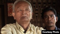 Nuon Chea (left), "Brother Number Two" of the Khmer Rouge regime, sits with documentary filmmaker Thet Sambath during an interview.