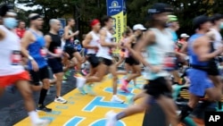 FILE - Runners cross the starting line of the 125th Boston Marathon, Monday, Oct. 11, 2021, in Hopkinton, Mass. (AP Photo/Mary Schwalm, File)