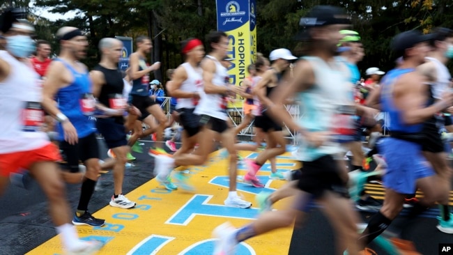 FILE - Runners cross the starting line of the 125th Boston Marathon, Monday, Oct. 11, 2021, in Hopkinton, Mass. (AP Photo/Mary Schwalm, File)