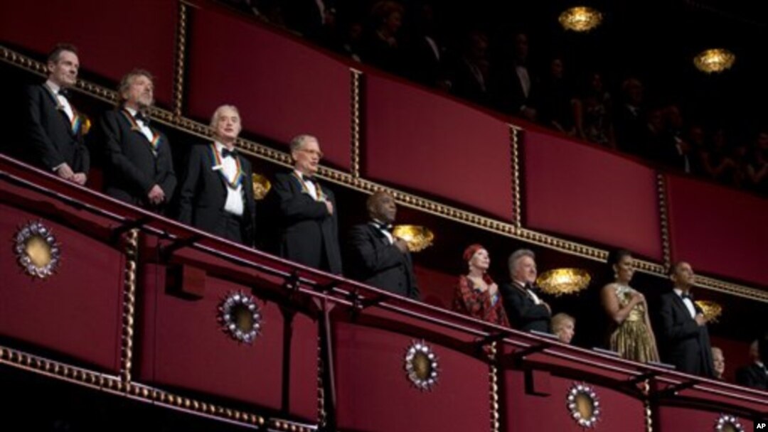 Presiden Barack Obama (kanan) dan ibu negara AS, Michelle Obama (dua dari kanan), bersama para penerima penghargaan dari Kennedy Center 2012 (dari kiri) pemain bas/keyboard band Led Zeppelin John Paul Jones, penyanyi Robert Plant, gitaris Jimmy Page, komedian dan pembawa acara TV David Letterman, musisi blues Buddy Guy, balerina Natalia Makarova dan aktor Dustin Hoffman di Kennedy Center (2/12).