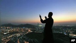 A Muslim pilgrim prays at the top of Noor Mountain near where the Hiraa cave is located, on the outskirts of Mecca, 11 Nov 2010.