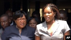 Zimbabwean deputy President Joice Mujuru, left, leaves the Harare magistrates court accompanied by her daughter Kumbirai in Harare, January 17, 2012