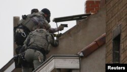 Les forces spéciales de la police belge sont sur le toit d'un immeuble au cours d’un raid, à la recherche de fondamentalistes musulmans présumés liés aux attentats meurtriers à Paris, à Molenbeek, dans la banlieue de Bruxelles, à Molenbeek, 16 novembre 2015.