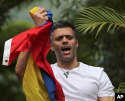FILE - Venezuela's opposition leader Leopoldo Lopez holds a national flag as he greets supporters outside his home in Caracas, Venezuela, following his release from prison, July 8, 2017.