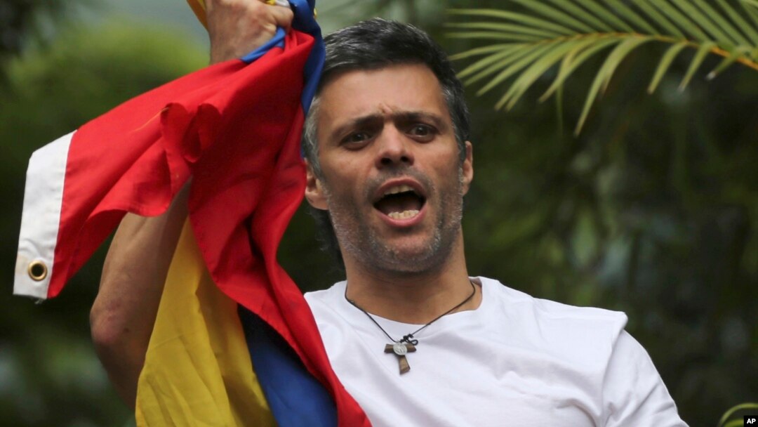 Tokoh oposisi Venezuela Leopoldo Lopez memegang bendera nasional saat menyambut pendukungnya di rumahnya di Caracas, Selasa (1/8). 