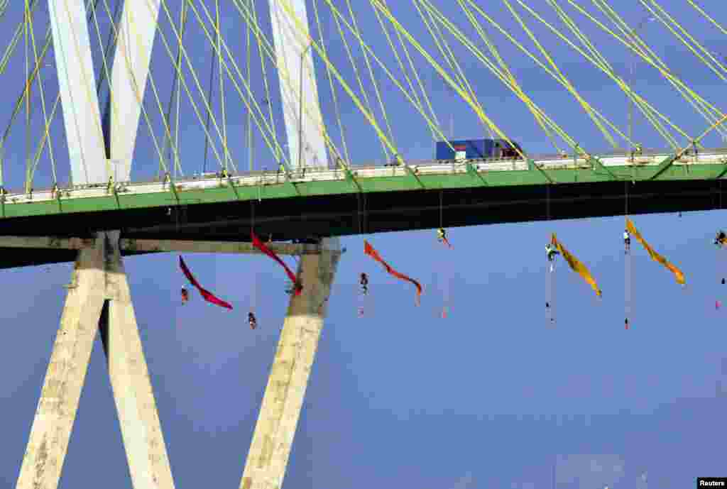 Greenpeace USA climbers form a blockade on the Fred Hartman Bridge, shutting down the Houston Ship Channel, the largest fossil fuel thoroughfare in the United States, ahead of the third Democratic primary debate in nearby Houston, near Baytown, Texas. (&copy;Anonymous/Greenpeace USA)