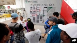 In this April 30, 2019, photo, Cynthia Mayrena, 29, of Nicaragua, describes how the list of asylum seekers works in Matamoros, Mexico. At least 800 people are still on the list, some for two months or longer, as they seek asylum in the U.S.