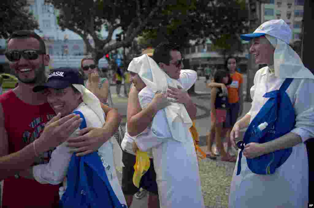 Pilgrims dance and sing at Copacabana beach ahead of Pope Francis&#39; visit to Rio de Janeiro July 21, 2013.