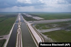 Canals run past the site, top right, where sugar cane fields are being converted into the Everglades Agricultural Area Reservoir, Wednesday, May 15, 2024, in South Bay, Fla.