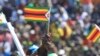 A supporter of Zimbabwean President Emmerson Mnangagwa waves a national flag, during a Heroes' Day event to commemorate the lives of those who died in the southern African country's 1970s war against white minority rule, in Harare, Aug. 13, 2018. 