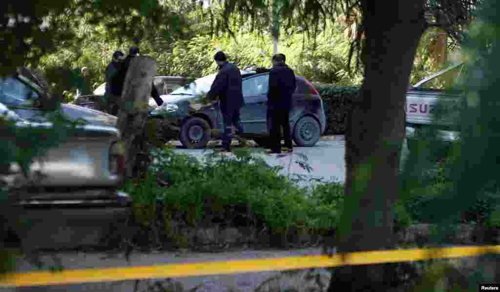 Forensic inspectors examine the car of Chokri Belaid, who was shot dead outside his home, in Tunis Feb. 6, 2013. 