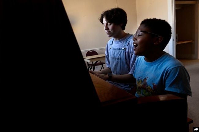 FILE - Grayson Hart and cast member Evan Roberts, 11, rehearse a song at the Ned R. McWherter West Tennessee Cultural Arts Center in Jackson, Tenn., on Saturday, March 4, 2023. (AP Photo/Mark Zaleski)