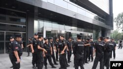 在2018年8月6日北京的中国银监会入口处，保安人员聚集。中国网络理财民间集资受害者准备到这里请愿。当局严阵以待。