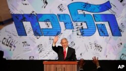 Israeli Prime Minister Benjamin Netanyahu waves to his supporters after the first exit poll results for the Israeli parliamentary elections at his Likud party's headquarters in Jerusalem, March. 24, 2021.