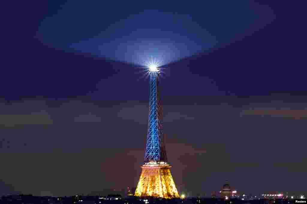 The Eiffel Tower is lit up in blue and yellow, the national colors of Ukraine, to mark the third anniversary of Russia&#39;s invasion of Ukraine, in Paris, France.