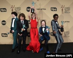 Finn Wolfhard, from left, Gaten Matarazzo, Millie Bobby Brown, Noah Schnapp, and Caleb McLaughlin pose in the press room with the awards for outstanding performance by an ensemble in a drama series for "Stranger Things" at the 23rd annual Screen Actors Gu